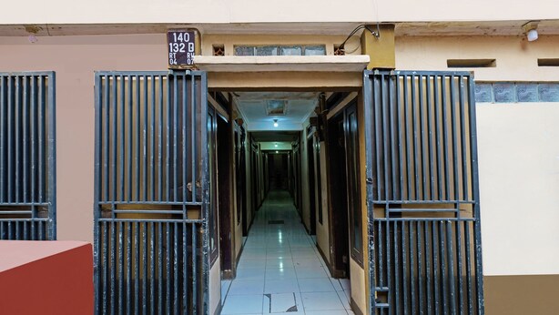 A hallway with a tiled floor and metal gates at the entrance. - SPOT ON 91783 Urban Syariah ResidenceNearGOR Pandawa Lima (Bandung)