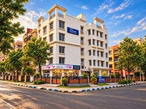 Un hôtel à plusieurs étages, avec une enseigne indiquant « The Altruist Business Stays ».