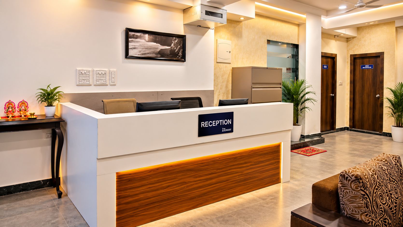 A reception desk with a sign, a framed picture on the wall, and a plant on the counter.