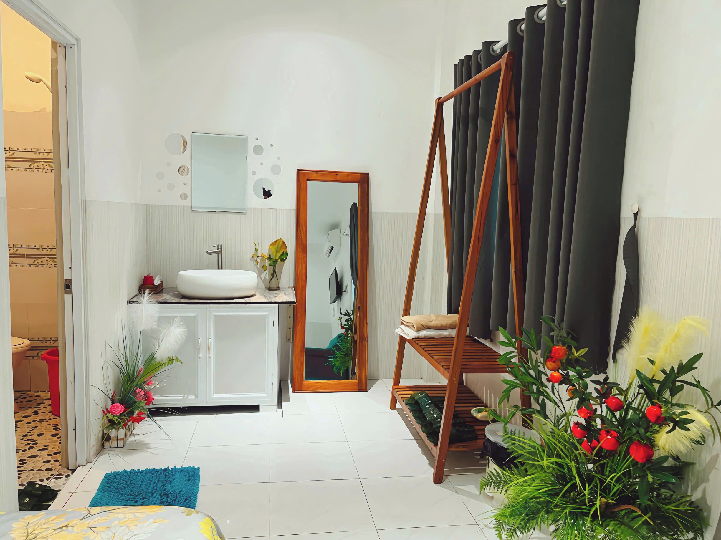 A modern bathroom with a white sink, mirror, and wooden swing chair.