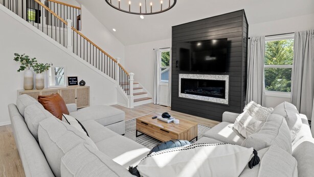 A modern living room with a staircase, a fireplace, and a large window. - 4 King Luxury MTN Home | 3 min Downtown Black MTN | 17 min to Asheville (Black Mountain)