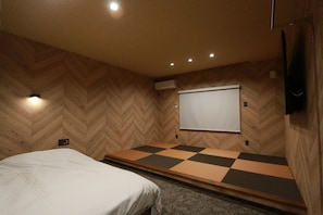 A room with a bed, a checkered floor, a whiteboard, and a mounted TV.