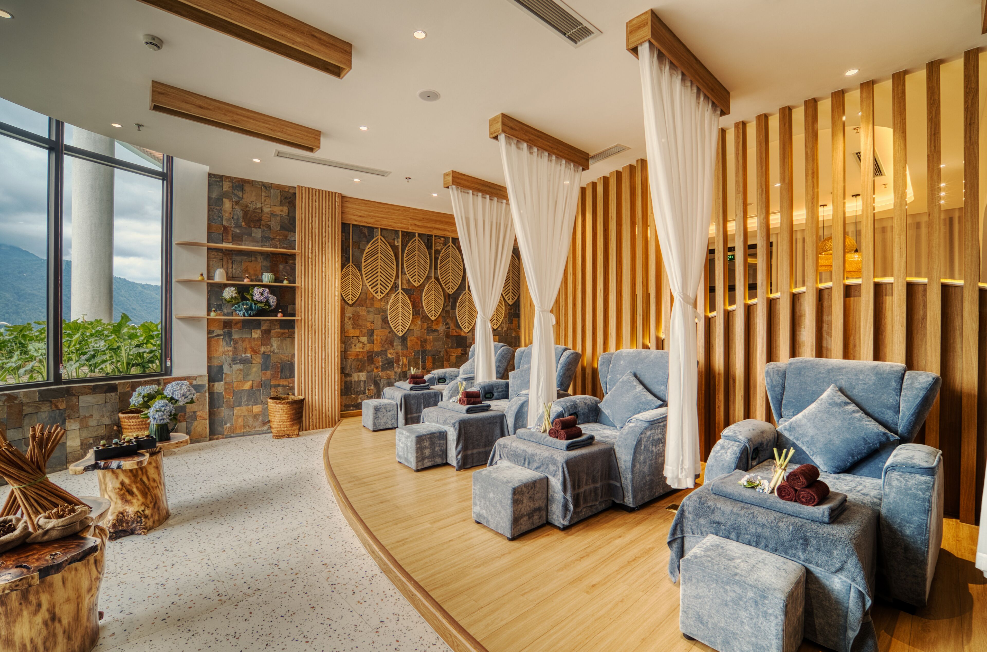 Une salle de spa équipée de fauteuils de massage, avec un mur en pierre et une vue sur les montagnes.