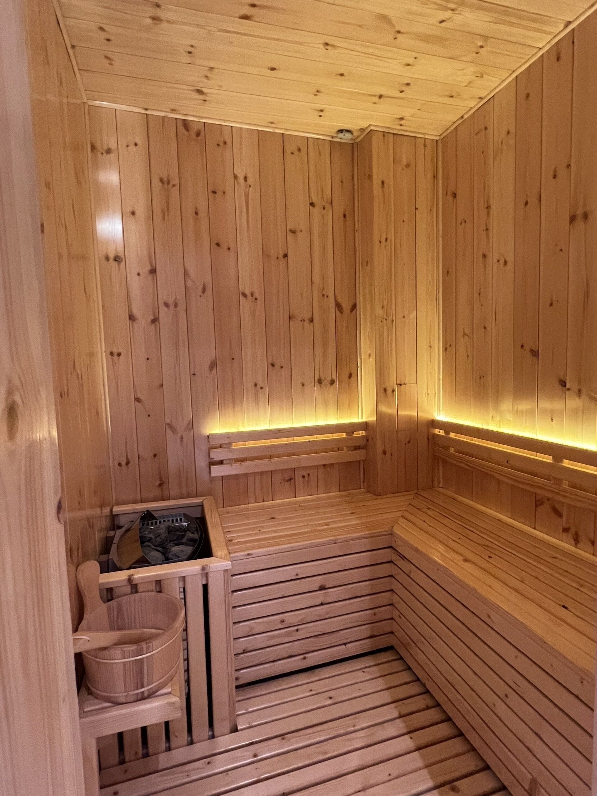 A wooden sauna with benches and a bench seat.