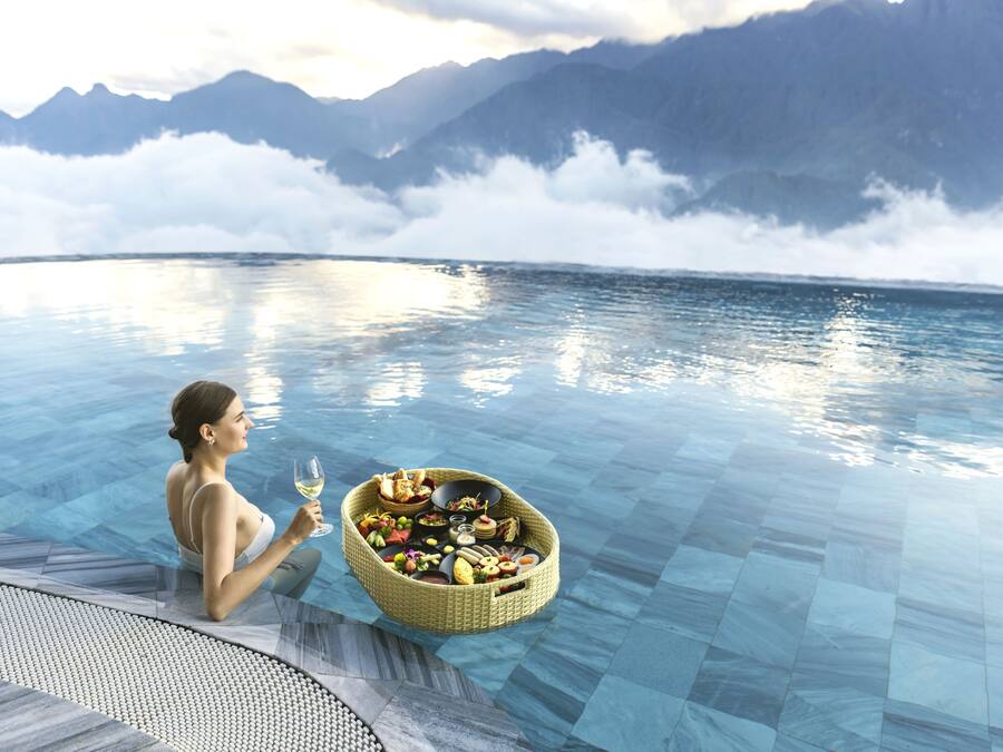 Una piscina techada, una piscina al aire libre, sombrillas