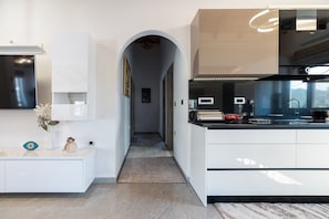 A modern kitchen with white cabinetry, a black countertop, and a visible stove. - Villa 'Despina' with Sea View, Wi-Fi and Air Conditioning (Rhodes)