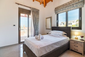 A bedroom with a bed, a nightstand, a mirror, a window with a view, and a door leading to an outdoor area. - Villa 'Despina' with Sea View, Wi-Fi and Air Conditioning (Rhodes)
