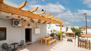 An outdoor patio with a wooden pergola, a table with benches, and a grill. - Villa 'Nikolaos' with Sea View, Wi-Fi and Air Conditioning (Rhodes)