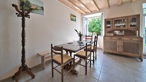 Un comedor con mesa de madera, sillas, un banco y un armario.