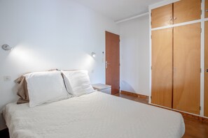 Ein Schlafzimmer mit einem Bett, einem Holzschrank und einem Nachttisch.