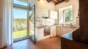 A kitchen with a large window, a stove, and a sink.