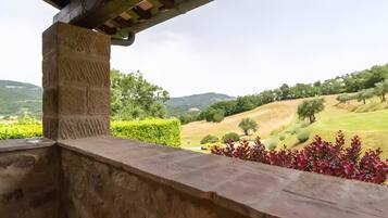 A stone structure with a view of a green landscape and hills.