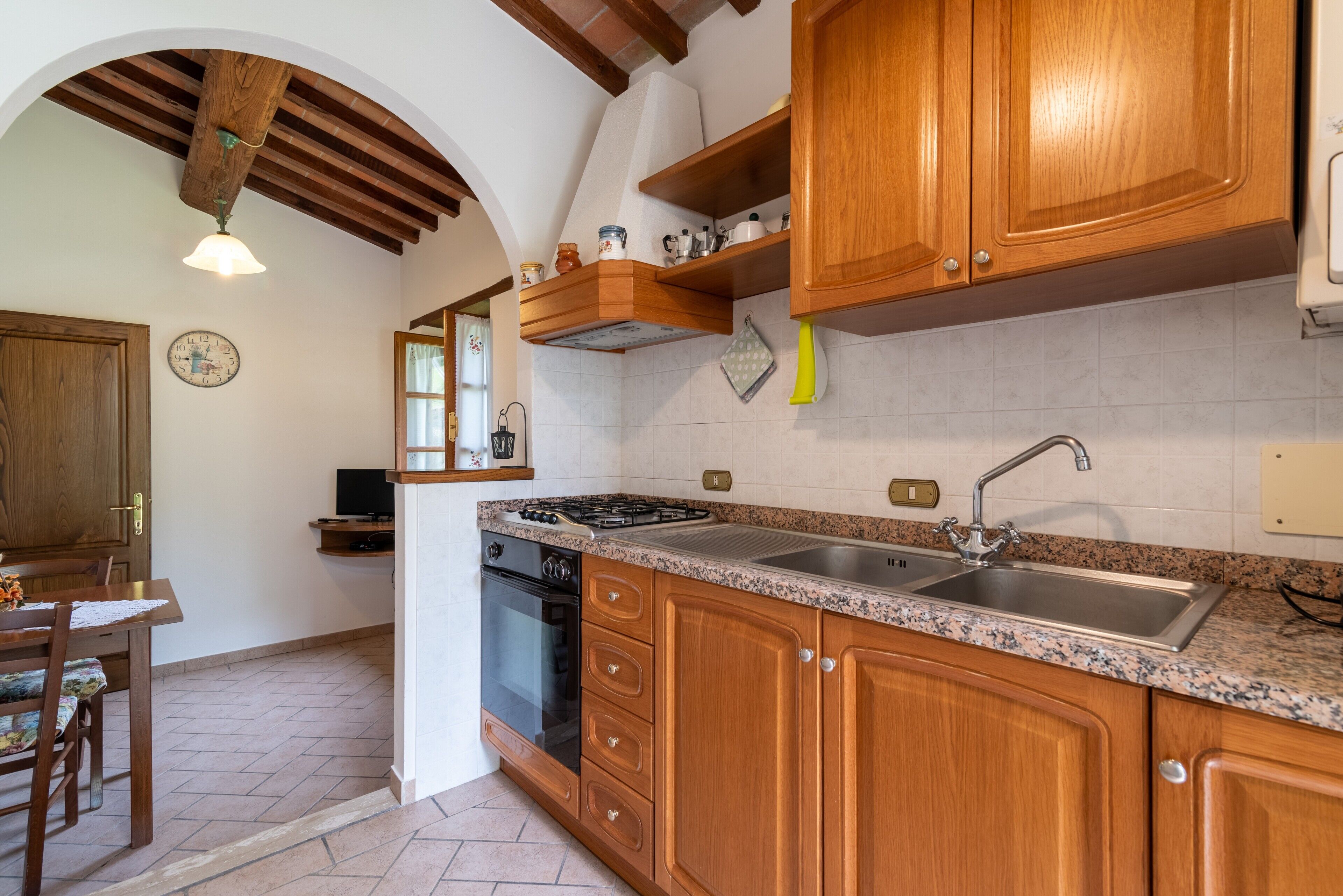 A kitchen with wooden cabinets, a granite countertop, a stove, and a sink.