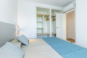 A room with a bed, a wardrobe, and a hanging closet.