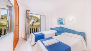 A hotel room with two beds, a large window, and a view of greenery. - Apartment 'Oro del Mar IV 01' with Shared Pool, Garden, and Wi-Fi (Canyamel)