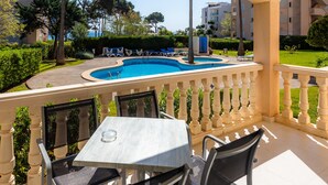 Un balcón con piscina, sillas y una mesa.