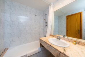 Une salle de bain avec une baignoire, un lavabo et une douche.