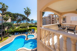 Une piscine avec des chaises longues, une vue sur la mer et un balcon doté d’une balustrade.