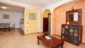Un amplio espacio de sala de estar con una mesa de comedor, una mesa de centro y un mueble decorativo con azulejos.