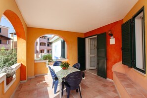 A dining area with a table and chairs, a window, and a door with a number sign.