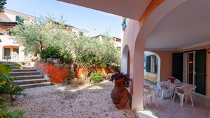 A courtyard with a patio area, a large vase, and a table with chairs. - Apartment "Alloro" with Terraces & Wi-Fi (Sos Alinos)