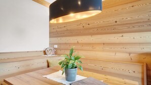 Een houten bank met een bloempot, een tafel met een notitieboekje en een zwarte lamp.