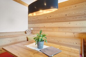 A wooden bench with a potted plant, a table with a notebook, and a black lamp. - Apartment 'Nelkenstein Frühling' with Mountain View, Shared Pool and Wi-Fi (Scena)