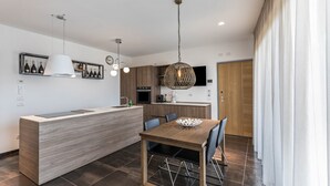 Una cucina moderna con isola centrale, illuminazione a sospensione e zona pranzo con sedie.