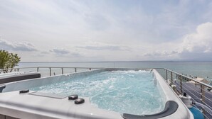 Ein Whirlpool mit Blick auf das Meer und einen bewölkten Himmel.