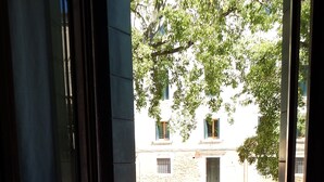 A room with a large window, a view of a courtyard, and a window sill with cups. - Apartment 'Zen' with Sea View, Wi-Fi and Air Conditioning (Venice)