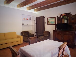 A room with a bed, a sofa, two armchairs, a television, a cabinet, and a painting on the wall. - Apartment 'Zen' with Sea View, Wi-Fi and Air Conditioning (Venice)