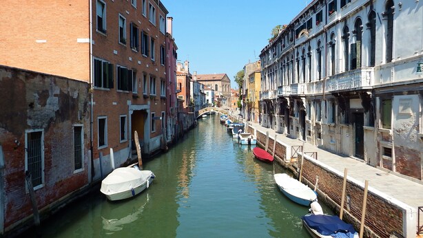 A narrow canal flanked by historic buildings with a bridge in the distance. - Apartment 'Zen' with Sea View, Wi-Fi and Air Conditioning (Venice)