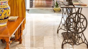 A hallway with a wooden table, a vase with flowers, and a sewing machine. - Terra d'Amuri Hotel (Catania)