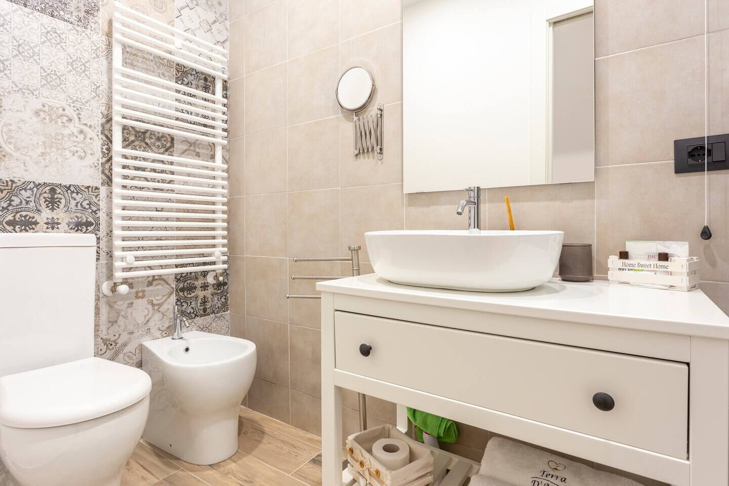 A bathroom with a toilet, bidet, white sink, and a mirror.