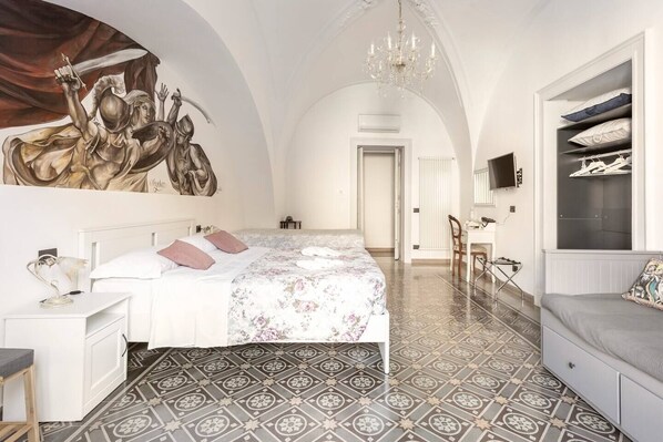 A spacious bedroom with a large bed, a desk, and a wardrobe. - Terra d'Amuri Hotel (Catania)