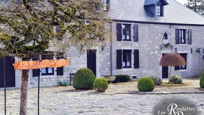 Un bâtiment en pierre sur lequel on peut lire l’inscription : « Les Roulottes à Riezes ».