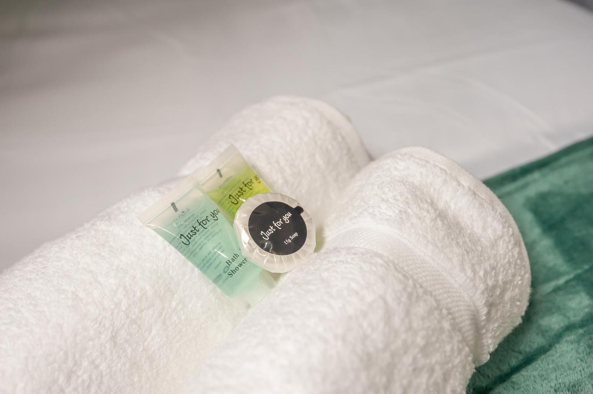 Une serviette blanche, un mètre ruban et un savon sont posés sur un lit.