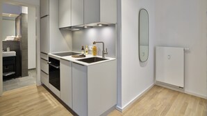 A modern kitchen with white cabinets, a built-in oven, and a sink.