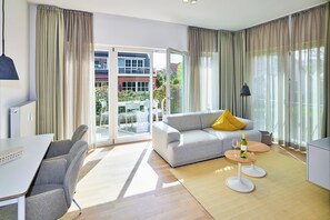 A modern living room with a sofa, a dining table, and a coffee table.