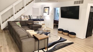 Relax in this stylish living space with a sofa, TV, and dining area.
