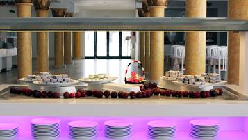 A buffet setup with multiple serving stations, including a central display with a decorative centerpiece and a row of plates at the front.