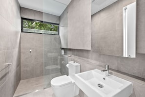 Ein modernes Badezimmer mit Dusche, Toilette und Waschbecken.