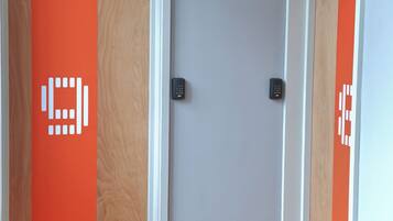 Two doors with a wooden frame and a grey wall.
