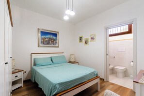 A bedroom with a bed, bedside table, and a nightstand. There is a bathroom with a toilet, sink, and mirror. - 3277 Guest House Eleonora - Camera Matrimoniale by Barbarhouse (Alliste)