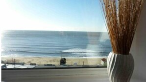 A view of the ocean from a window with a vase of dried reeds on the windowsill. - 2 Marine Parade , 2, ventnor, GB (ventnor)