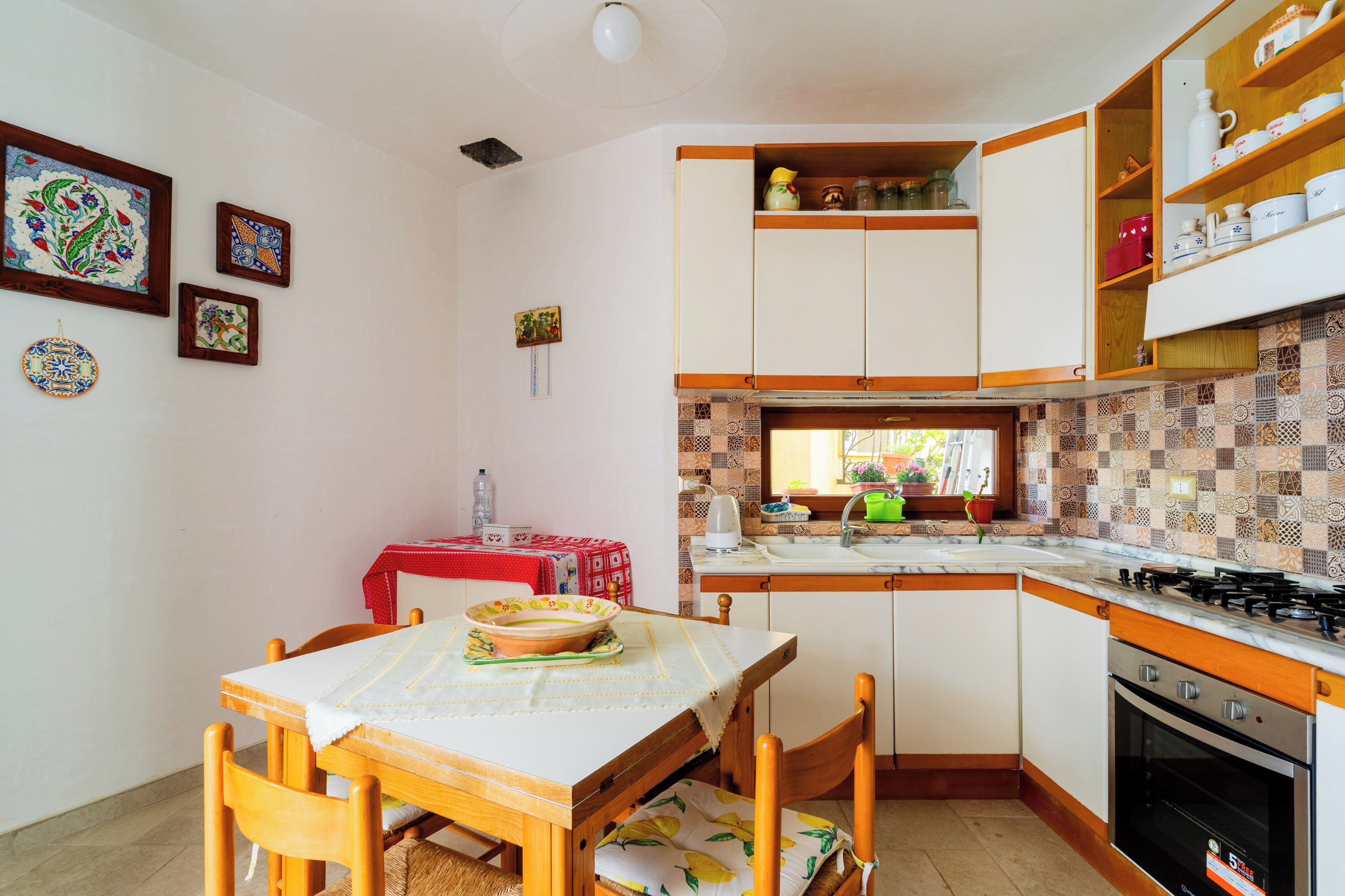 Une cuisine équipée d’une table à manger, de chaises, d’une cuisinière et de placards.