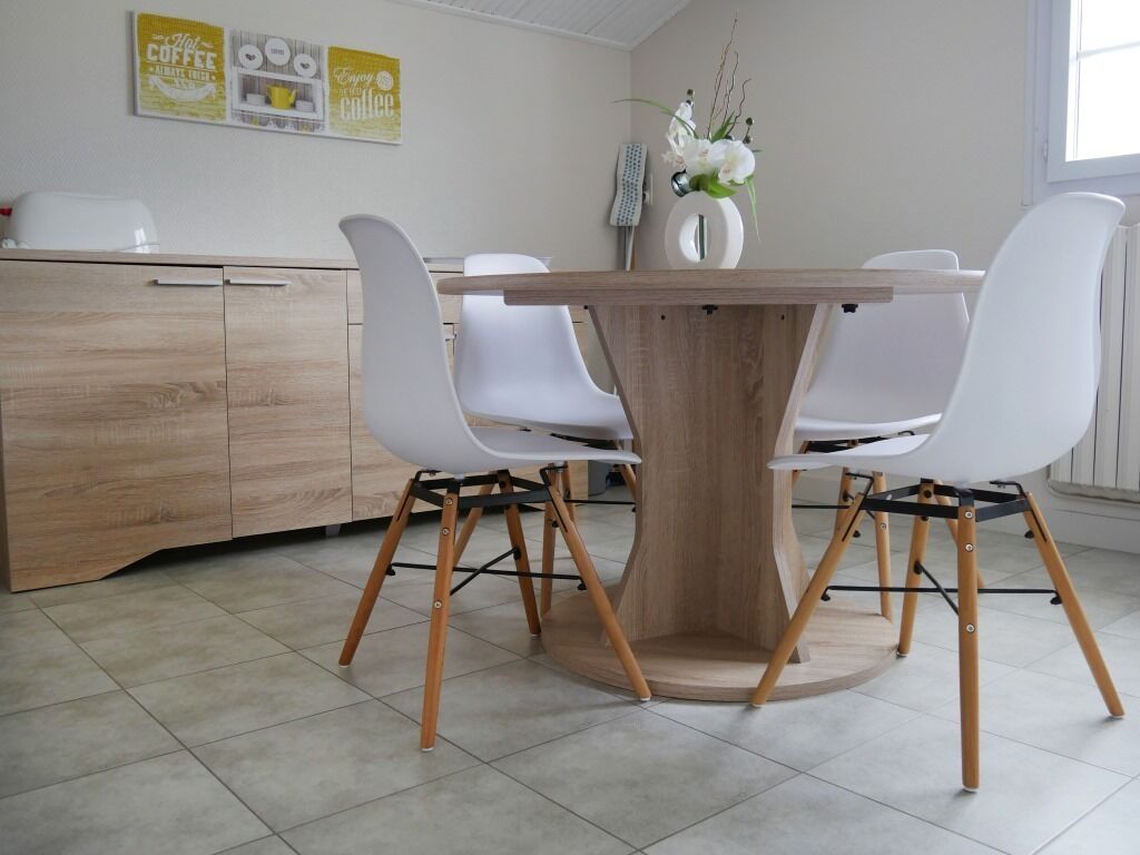 Un espace de restauration moderne avec une table en bois et des chaises blanches.