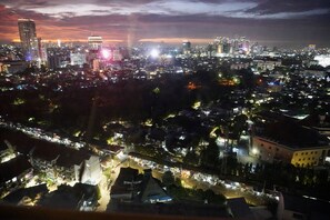 A nighttime cityscape with illuminated buildings and streets. - Series Hotel Sudirman (Jakarta)