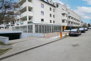 A modern apartment building with a covered entrance and a no parking sign.