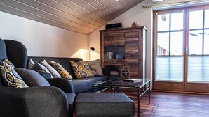 A cozy living room with a sofa set, ottoman, and a wooden cabinet. - Großzügige Wohnung für bis zu 5 Persone in Steibis (Oberstaufen)